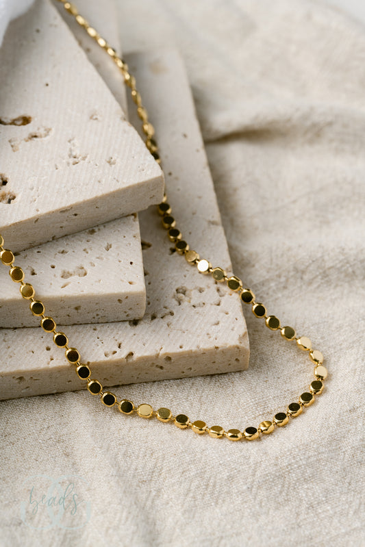 A gold plated chain necklace where each chain link is a small circle - tying into the "dot" name!