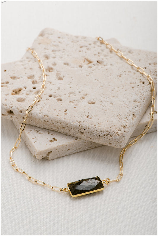 Gold, paperclip chain with a rectangular gemstone pendant.