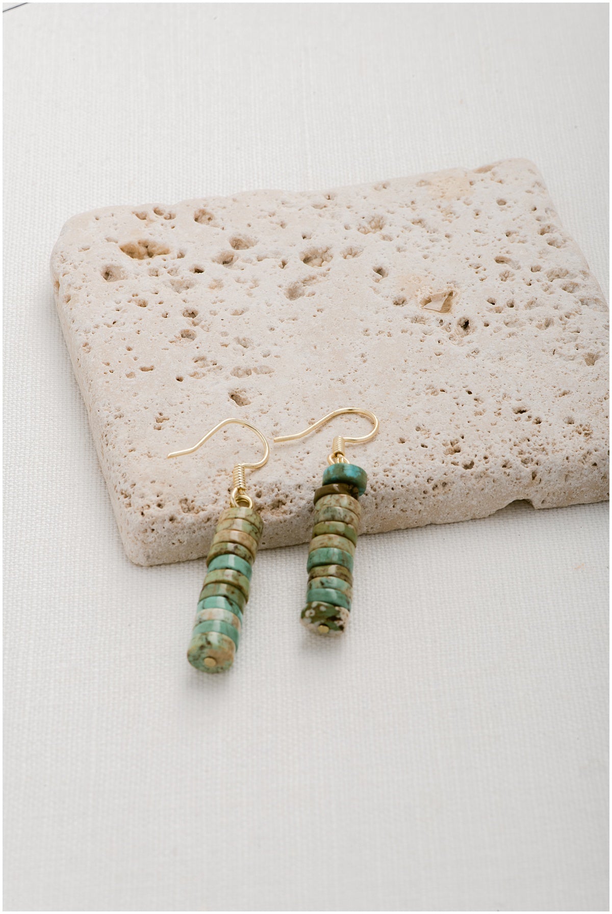Earrings with a stacked set of turquoise heishi discs.