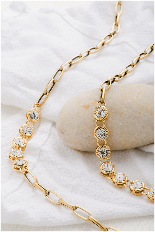 A gold chain with sets of five crystals alternating with gold paperclip chain.