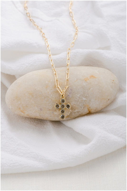 A gold paperclip chain with a round-cut crystal cross pendant.