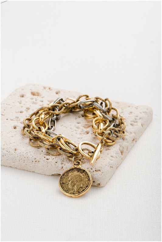 A luxurious triple-chain, mixed-metal design and regal coin pendant.
