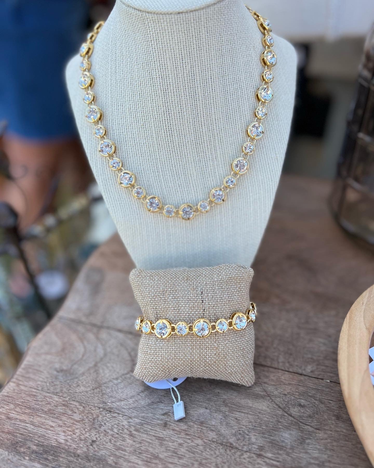 A gold necklace with two different-sized crystals alternating sizes throughout the necklace.