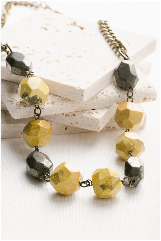 A bronze chain with ten stones on it. The colors and order of the stones are: turquoise, yellow, yellow, turquoise, yellow, yellow, turquoise, yellow, yellow, turquoise.